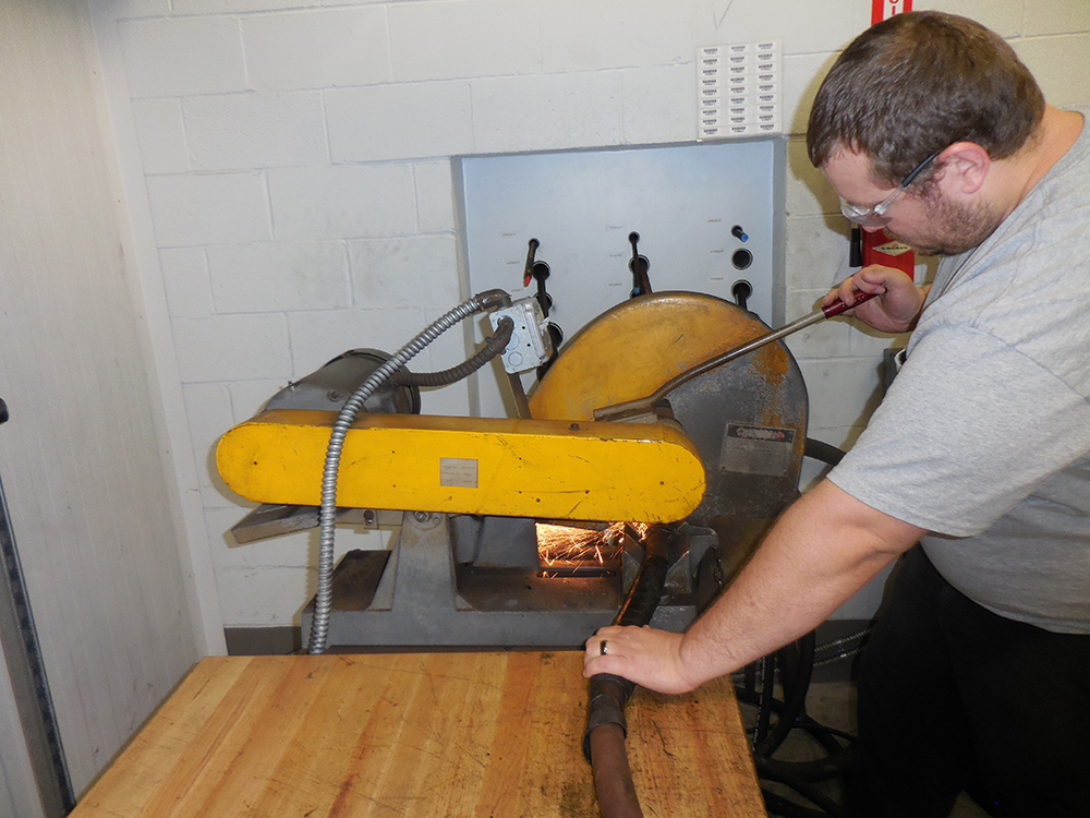 CB HYMAC technician repairing a hydraulic hose